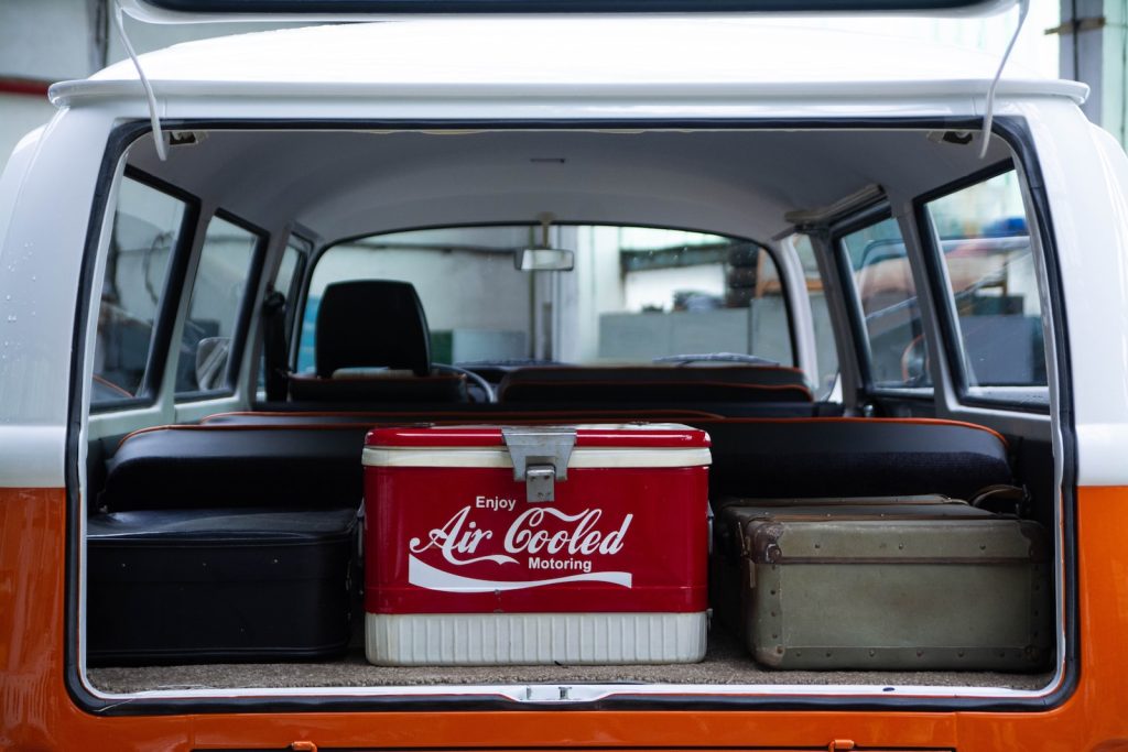 an orange and white truck with a cooler in the back