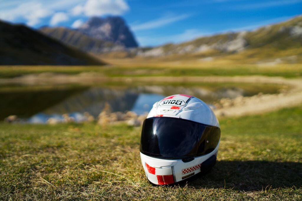 white and red helmet on green grass field during daytime